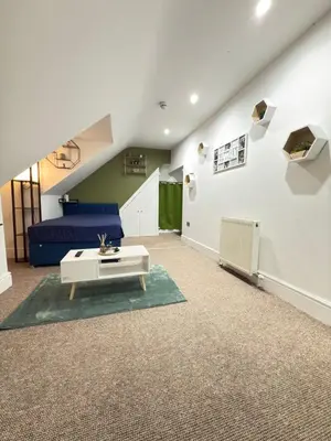a living room with a couch and a table at The Traveller's Nest by Cambridge Central Station in Cambridge