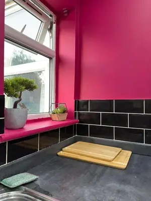 a bathroom with a pink wall and a wooden cutting board at The Squid Escape By Cambridge Central Station in Cambridge
