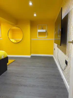 a yellow room with a mirror and a yellow wall at The Squid Escape By Cambridge Central Station in Cambridge