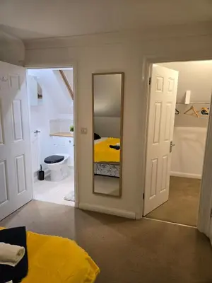 a bedroom with a yellow bed and a mirror at Duxford Haven in Duxford