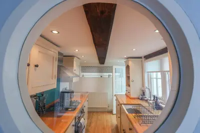 a kitchen with wooden counter tops and a mirror at The Nutshell in Aldeburgh