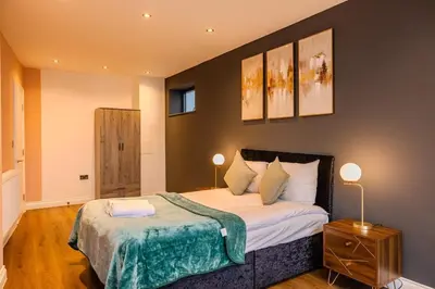 a bedroom with a large bed with two lamps on it at Lux 2 Bedroom Flt at Brentwood in Brentwood
