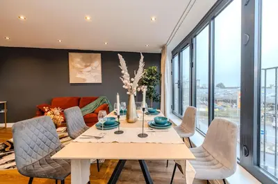 a dining room with a table and chairs at Lux 2 Bedroom Flt at Brentwood in Brentwood