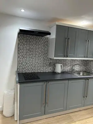 a kitchen with gray cabinets and a counter top at A Cosy and Luxurious Studioflat in Navestock