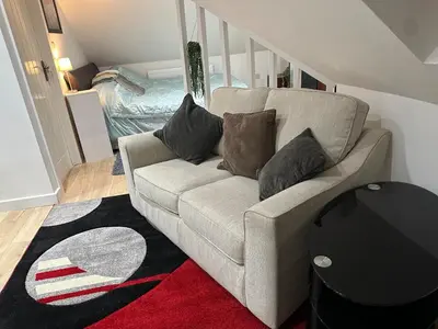a living room with a couch with pillows on it at A Cosy and Luxurious Studioflat in Navestock
