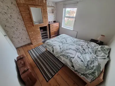 a bedroom with a bed and a dresser and a mirror at Room in Stowmarket in Stowmarket
