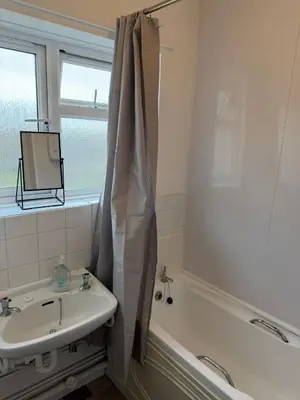 a bathroom with a sink and a tub and a mirror at Cozy 3 Bedroom Flat near Essex Uni, WiFi and Free Parking in Hythe