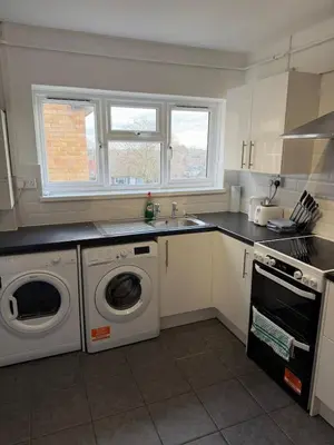 a kitchen with a washing machine and a sink at Cozy 3 Bedroom Flat near Essex Uni, WiFi and Free Parking in Hythe