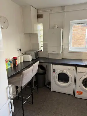 a kitchen with a washing machine and a washer and dryer at Cozy 3 Bedroom Flat near Essex Uni, WiFi and Free Parking in Hythe