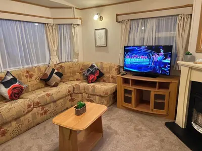 a living room with a couch and a flat screen tv at A & C Coastal Hideaway with outside Decking in East Mersea