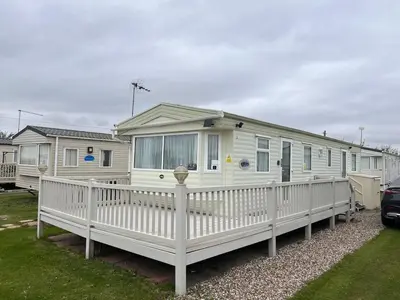 a white mobile home with a white fence at A & C Coastal Hideaway with outside Decking in East Mersea