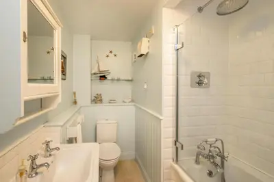 a bathroom with a toilet and a tub and a sink at 1 Ogilvie Lodge - A seafront apartment in Thorpeness - Close to Thorpeness Country Club - Managed by Aldeburgh Coastal Cottages in Thorpeness