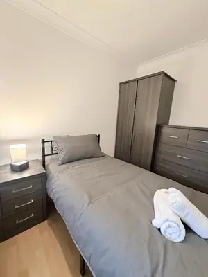 a bedroom with a bed with two towels on it at Stylish 3BR Cambridge Bungalow, Near Science Park in Cambridge
