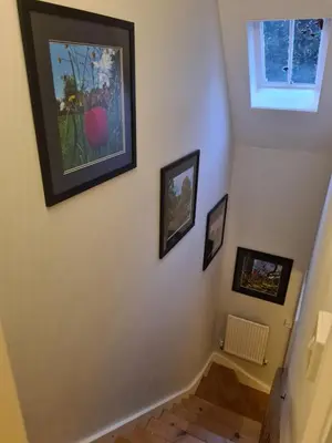 a hallway with three pictures on the wall at Idyllic, Private and Picturesque Cottage in Newmarket