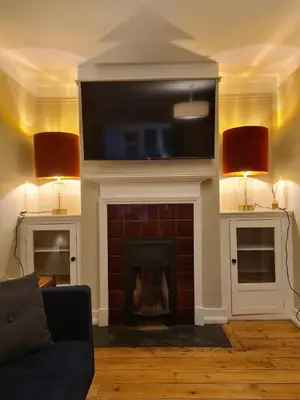 a living room with a fireplace with a flat screen tv at Idyllic, Private and Picturesque Cottage in Newmarket