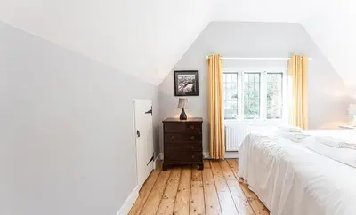 a white bedroom with a bed and a window at Idyllic, Private and Picturesque Cottage in Newmarket