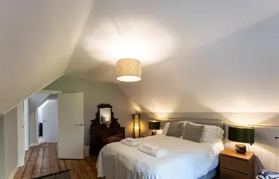 a bedroom with a white bed and a ceiling at Idyllic, Private and Picturesque Cottage in Newmarket