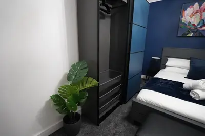 a bedroom with a bed and a plant in it at Premium 3BR House - Loughton - by Rent Squared LTD in Loughton