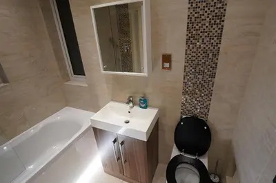 a bathroom with a sink and a toilet and a tub at Premium 3BR House - Loughton - by Rent Squared LTD in Loughton