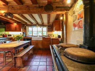 a kitchen with a table and a bench in it at Town Farm in Eye