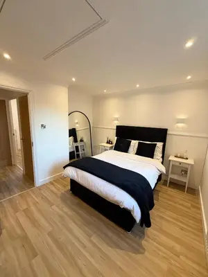 a bedroom with a large bed and two tables at The Waldegraves Hideaway in Bures Saint Mary