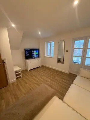 a living room with a couch and a tv at The Waldegraves Hideaway in Bures Saint Mary