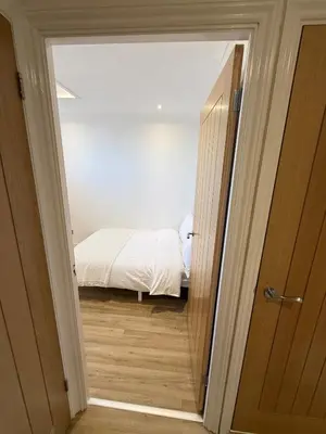 a bedroom with a bed and a door leading into a room at The Waldegraves Hideaway in Bures Saint Mary