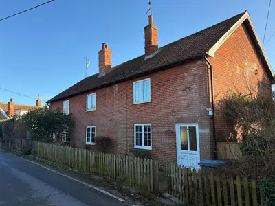 an old red brick house with a wooden fence at Beautiful Four Bedroom Cottage in Little Glemham, Suffolk in Little Glenham