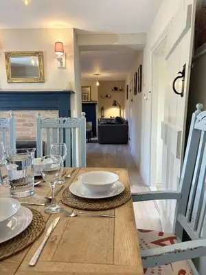 a table with plates and glasses on top of it at Beautiful Four Bedroom Cottage in Little Glemham, Suffolk in Little Glenham