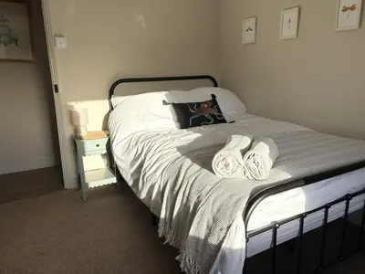 a bedroom with a bed with two towels on it at Beautiful Four Bedroom Cottage in Little Glemham, Suffolk in Little Glenham