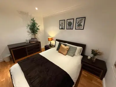 a bedroom with a bed with white sheets and pillows at Large 5BR House with FREE Parking and WiFi plus Garden in Basildon, Essex in Basildon