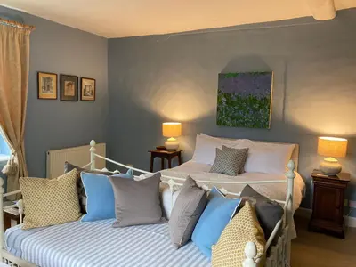 two beds in a bedroom with blue and white pillows at Grange Farm in Thetford