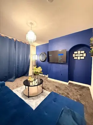a living room with blue walls and a table at Royal 4 Bed House By City Centre in CBG