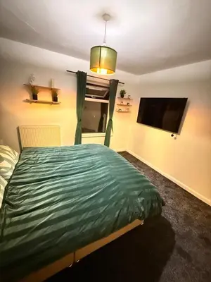 a bedroom with a bed and a flat screen tv at Royal 4 Bed House By City Centre in CBG