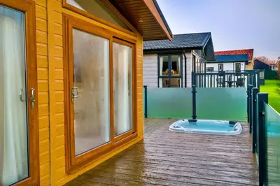 a house with a large sliding glass door at Finest Retreats - Heron Luxury Lodge