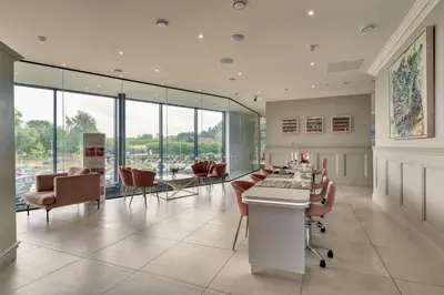 a conference room with a table and chairs and windows at Finest Retreats - Heron Luxury Lodge