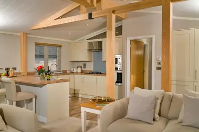 a kitchen and living room with a couch and a table at Finest Retreats - Heron Luxury Lodge