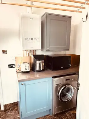 a kitchen with a microwave and a washer and dryer at Central Cambridge with Free Parking and Pets welcome in Chesterton