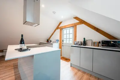 a kitchen with white cabinets and a counter top at Hare View, part of The Garden House in Kenninghall
