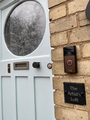 a white door with a window on a brick wall at 'The Artist's Loft' - Studio Flat in Cambridge in Cambridge