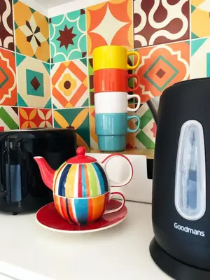 a tea pot sitting on a plate next to a toaster at 'The Artist's Loft' - Studio Flat in Cambridge in Cambridge