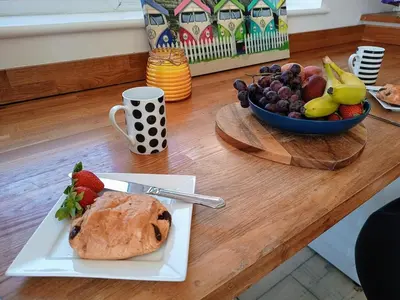 a plate with a loaf of bread and a bowl of fruit at Bungalow with a view in Kirby Cross