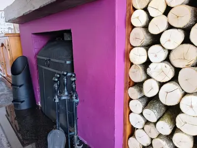 a pink wall with a pile of wood next to a trash can at Bungalow with a view in Kirby Cross