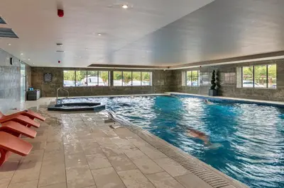 a large swimming pool in a building with a large swimming pool at Finest Retreats - Pembroke Luxury Lodge