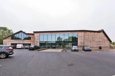 a large building with cars parked in a parking lot at Finest Retreats - Pembroke Luxury Lodge