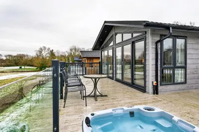 a house with a hot tub on a deck at Finest Retreats - Pembroke Luxury Lodge