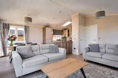 a living room with two couches and a table at Finest Retreats - Pembroke Luxury Lodge