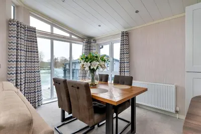 a dining room with a wooden table and chairs at Finest Retreats - Churchill Luxury Lodge