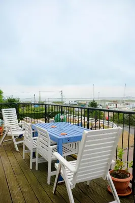three chairs and a blue table on a deck at The Victory at Mersea in West Mersea