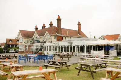 a group of picnic tables in front of a building at The Victory at Mersea in West Mersea